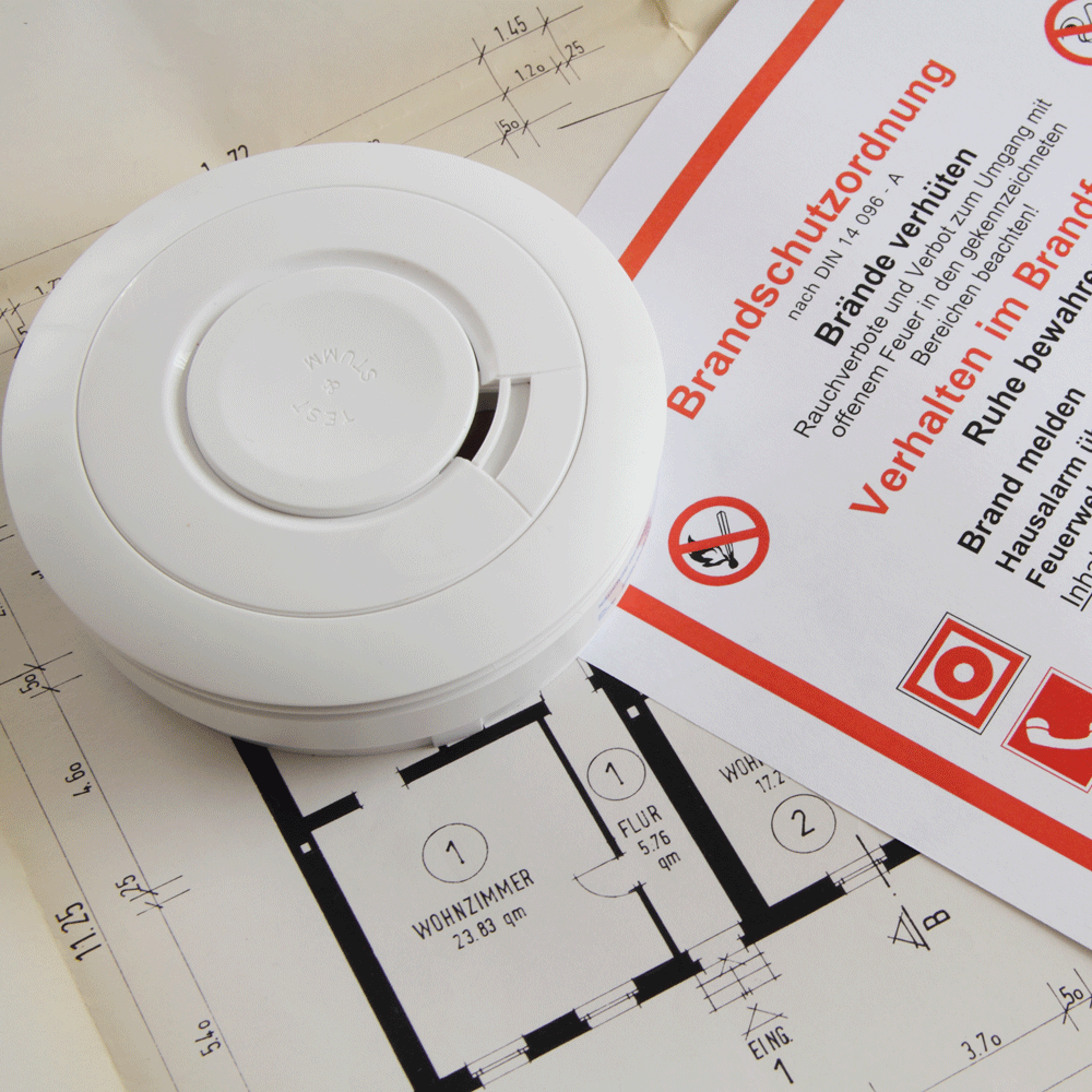 Brandschutz Rauchmelder auf einem Grundriss mit Sicherheitshinweisen daneben.
